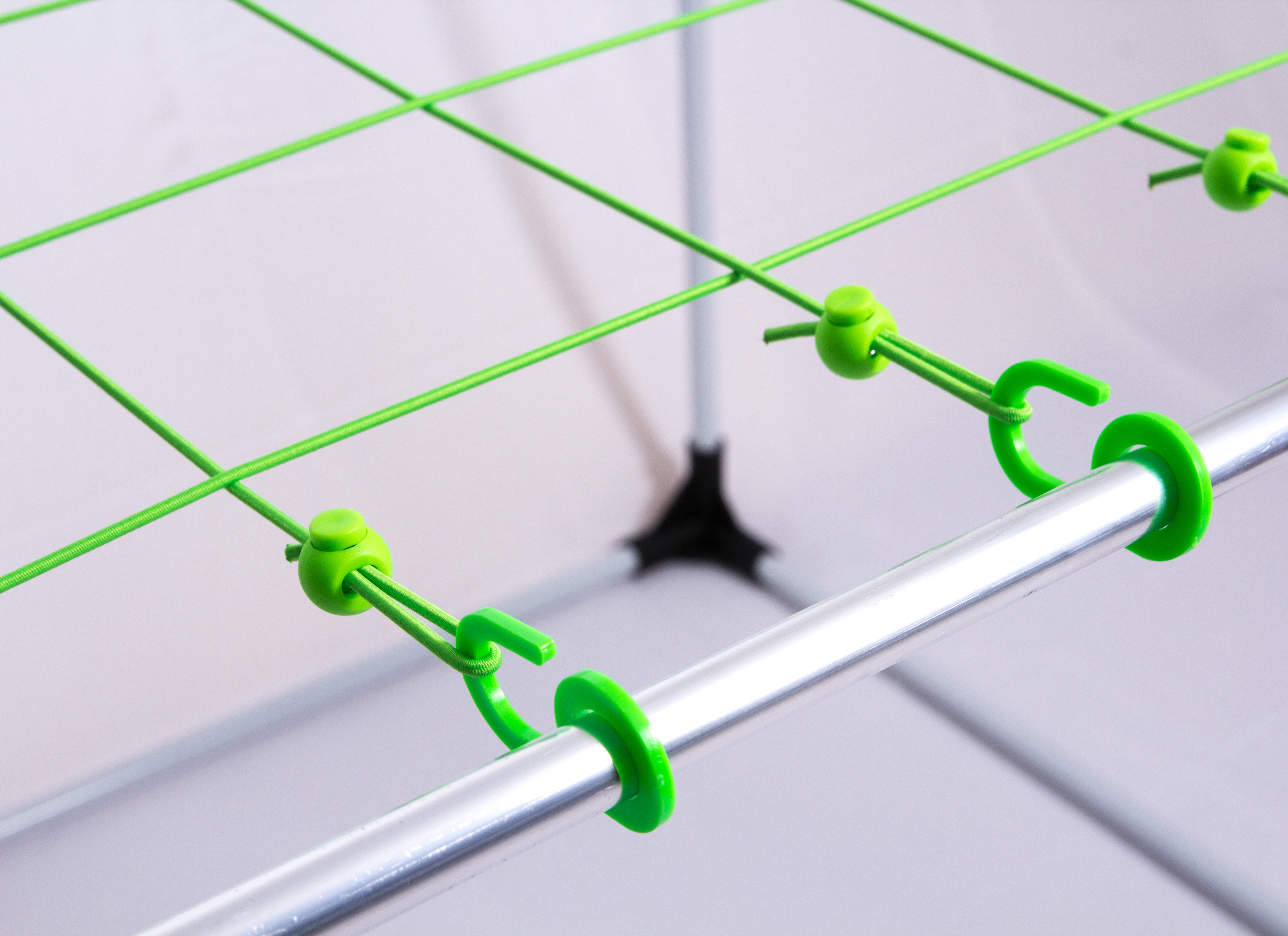 Das fertige Betternet: grüne Bänder, Stopper und Haken am Metallrahmen